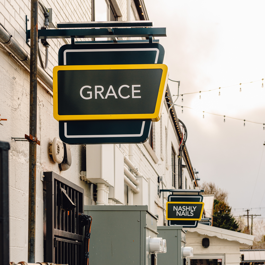 Coordinated set of illuminated tenant blade signs installed across storefronts at Gold’s Marketplace