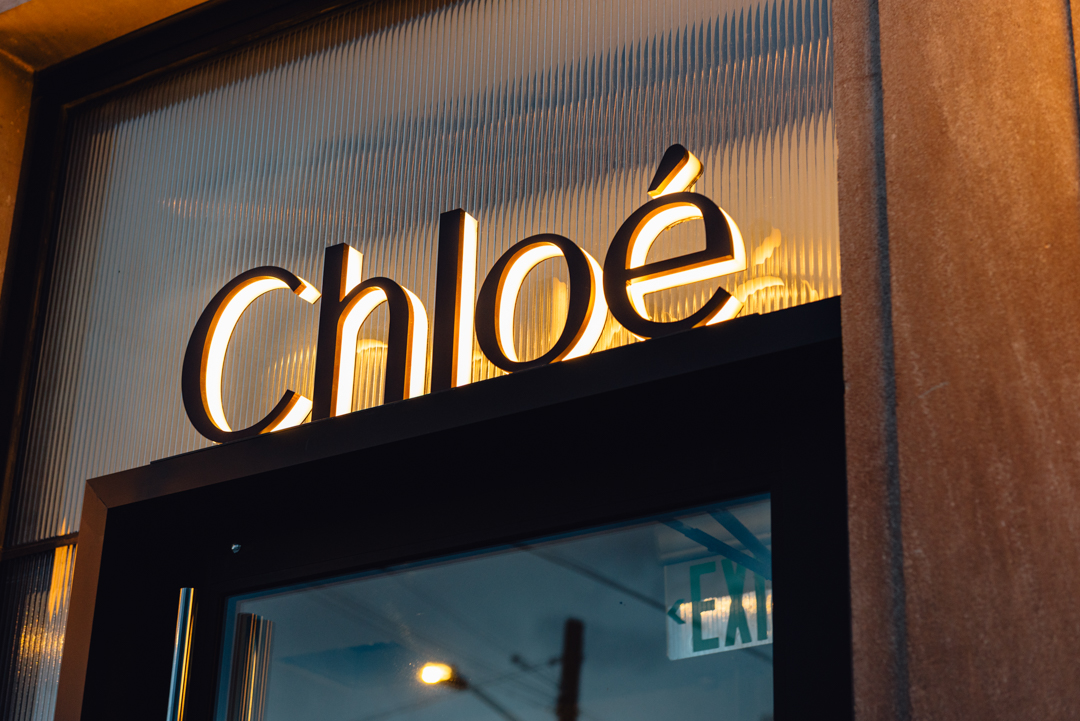 Close-up of custom reverse halo-lit Chloé letters with warm LED illumination.