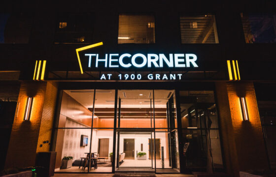 Illuminated multifamily signage and architectural lighting installed above the entrance at The Corner at 1900 Grant.